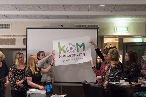 Pedagogisch medewerkers onthullen nieuw logo van KOM Kinderopvang